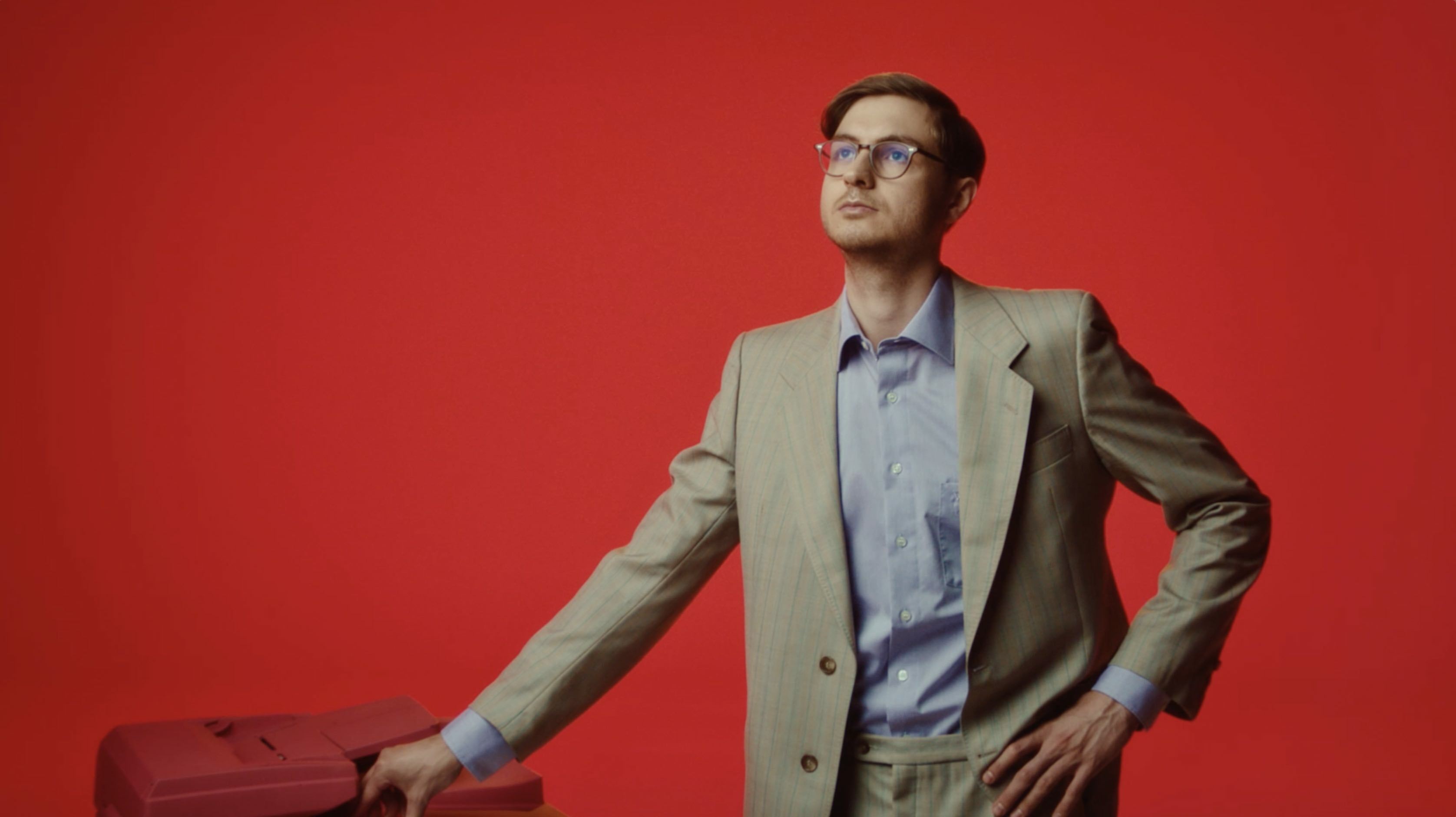 a man standing in front of a red wall